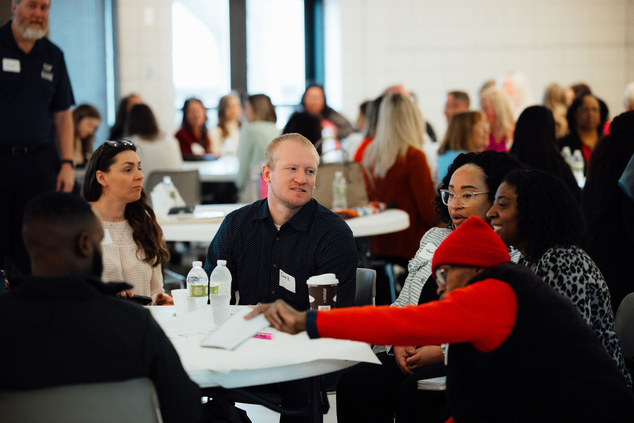 A diverse group of people sitting at a table during an Advancing Equity in the Cedar Valley event.