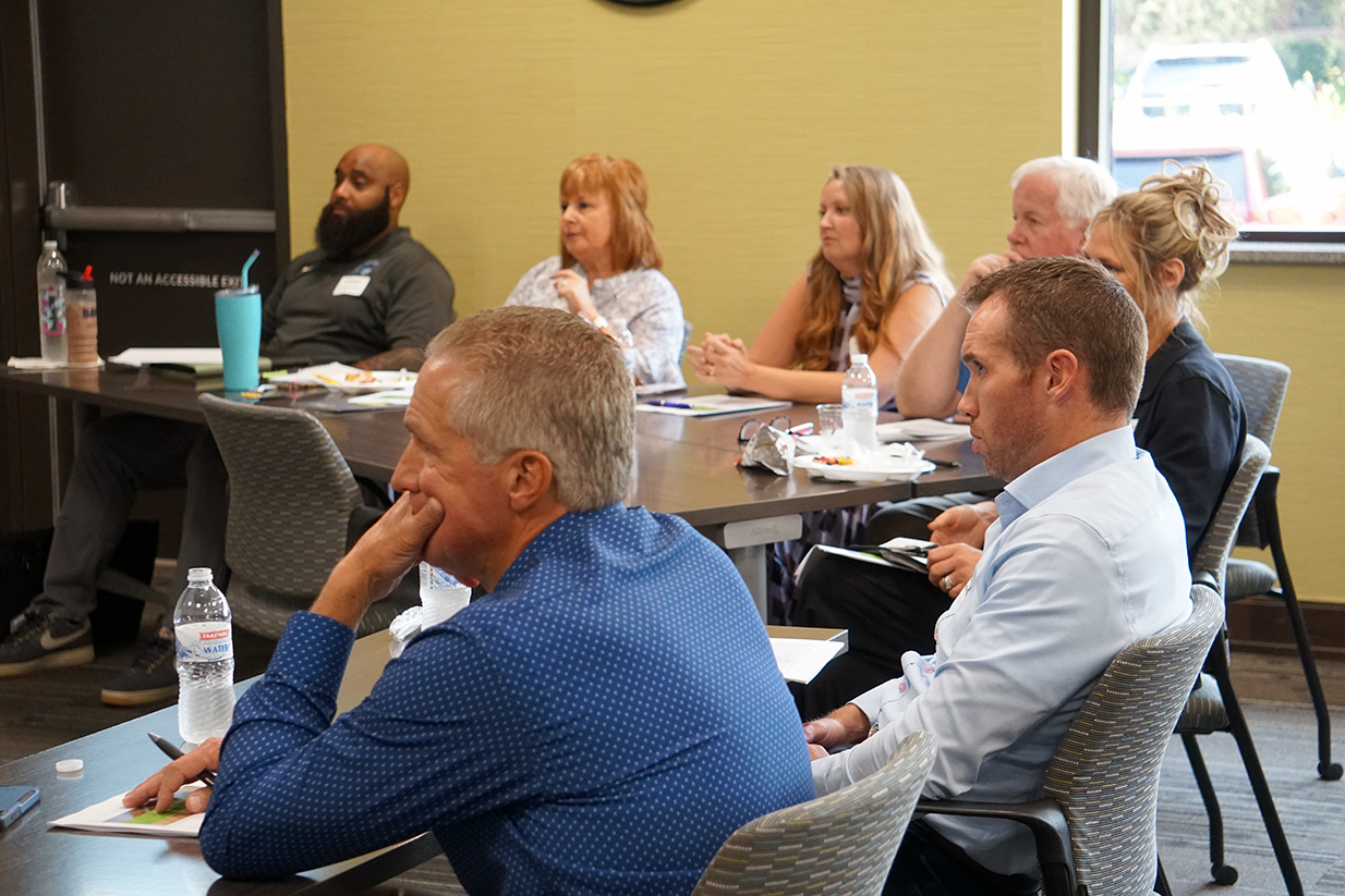 A group of financial advisors and attorneys listen to a speaker.