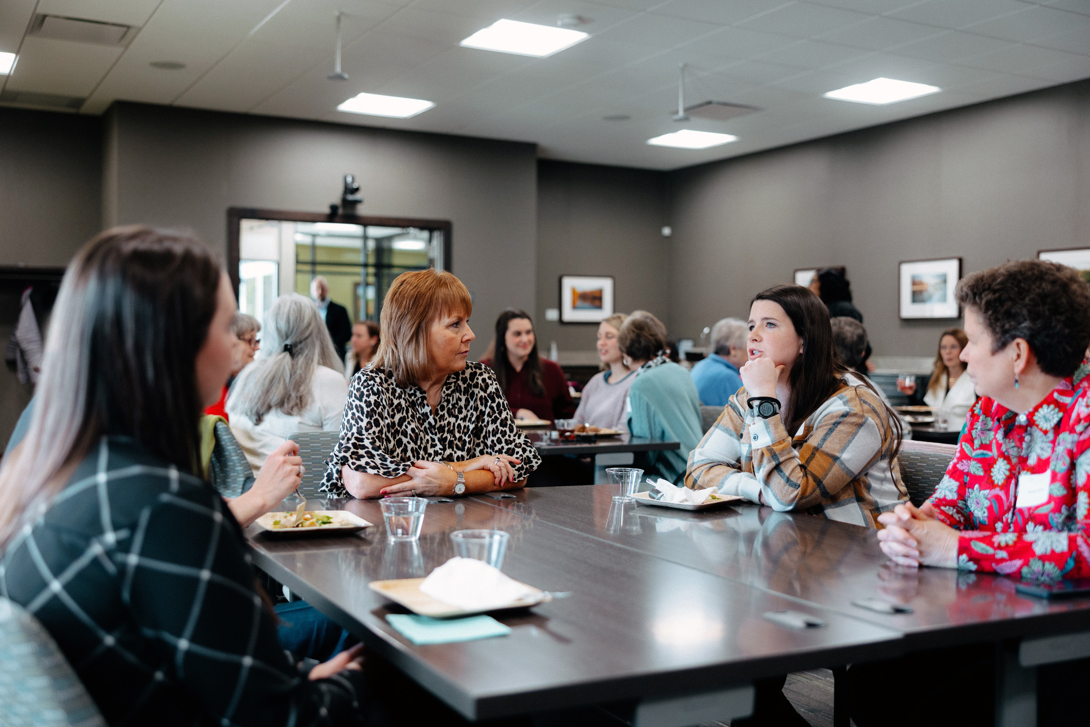 A group of women sit around a table at a Women for Good event.